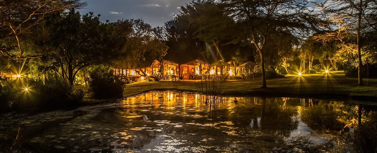 Chui Lodge lit at night beside water