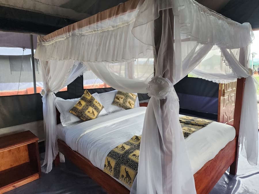 Side view of a mosquito-net bed inside an Endeem Mara tented room